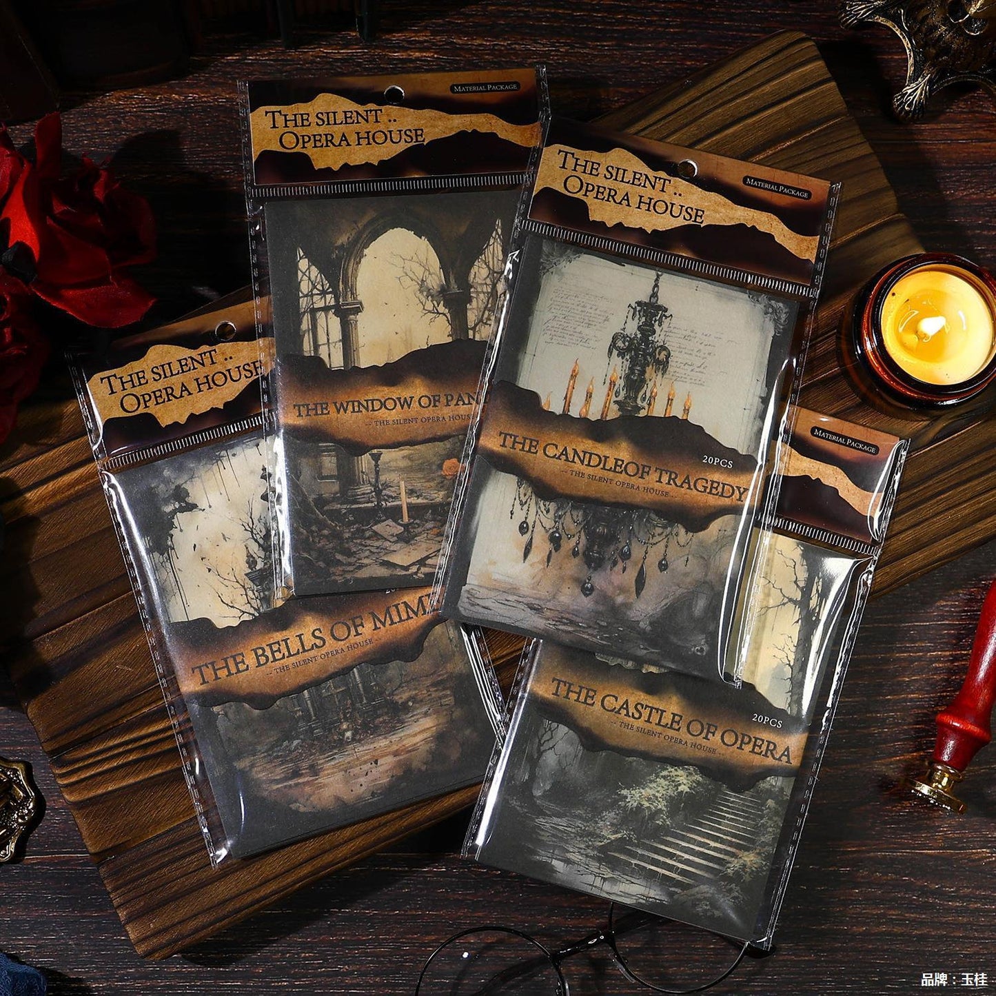 Packaged cards from 'The Silent Opera House' on a wooden surface with candles and decorative items.