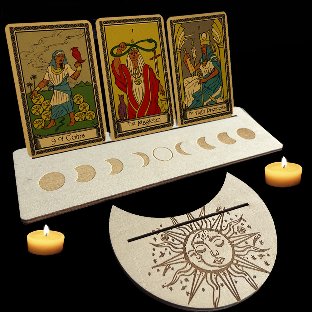Three tarot cards on a stand with candles and a sun and moon design on a black background