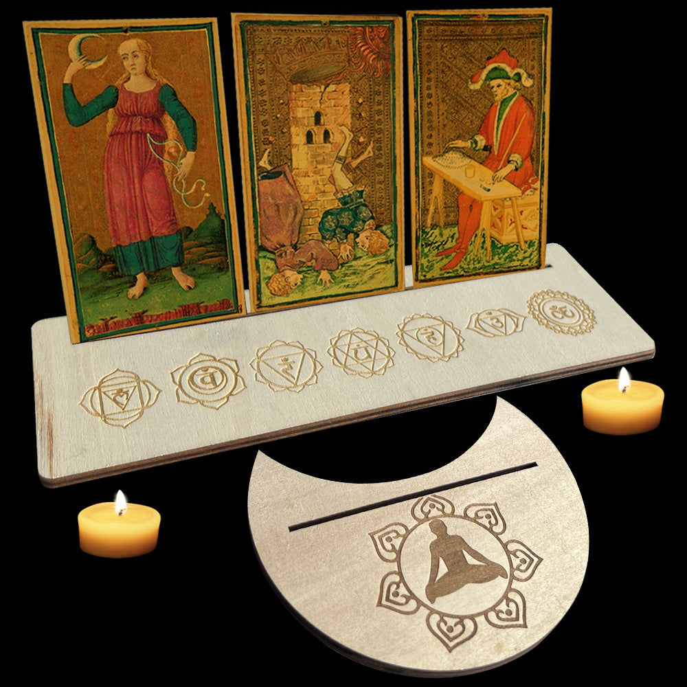 Three tarot cards on a stand with candles and a moon symbol on a black background