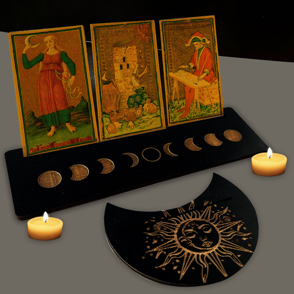 Three tarot cards on a stand with candles and a moon phase display on a dark background