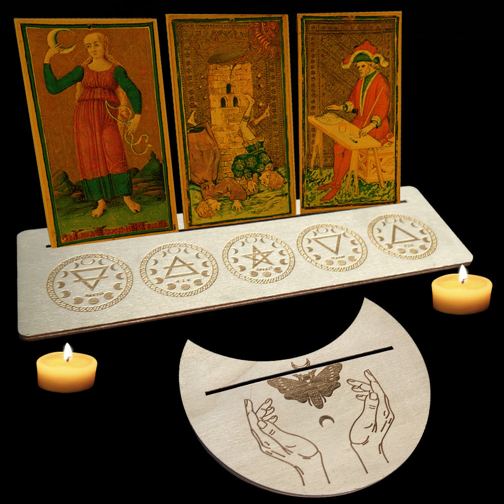 Three tarot cards on a stand with symbols, surrounded by candles on a dark background