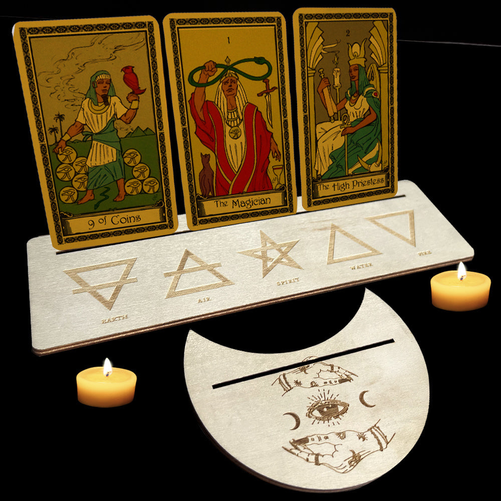 Three tarot cards on a stand with candles and wiccan symbols on a black background