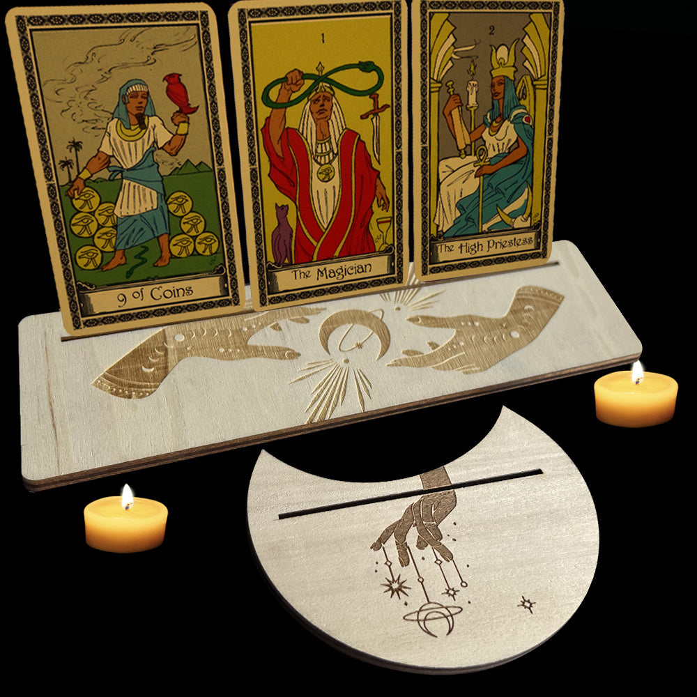 Three tarot cards on a wooden stand with candles on either side against a black background
