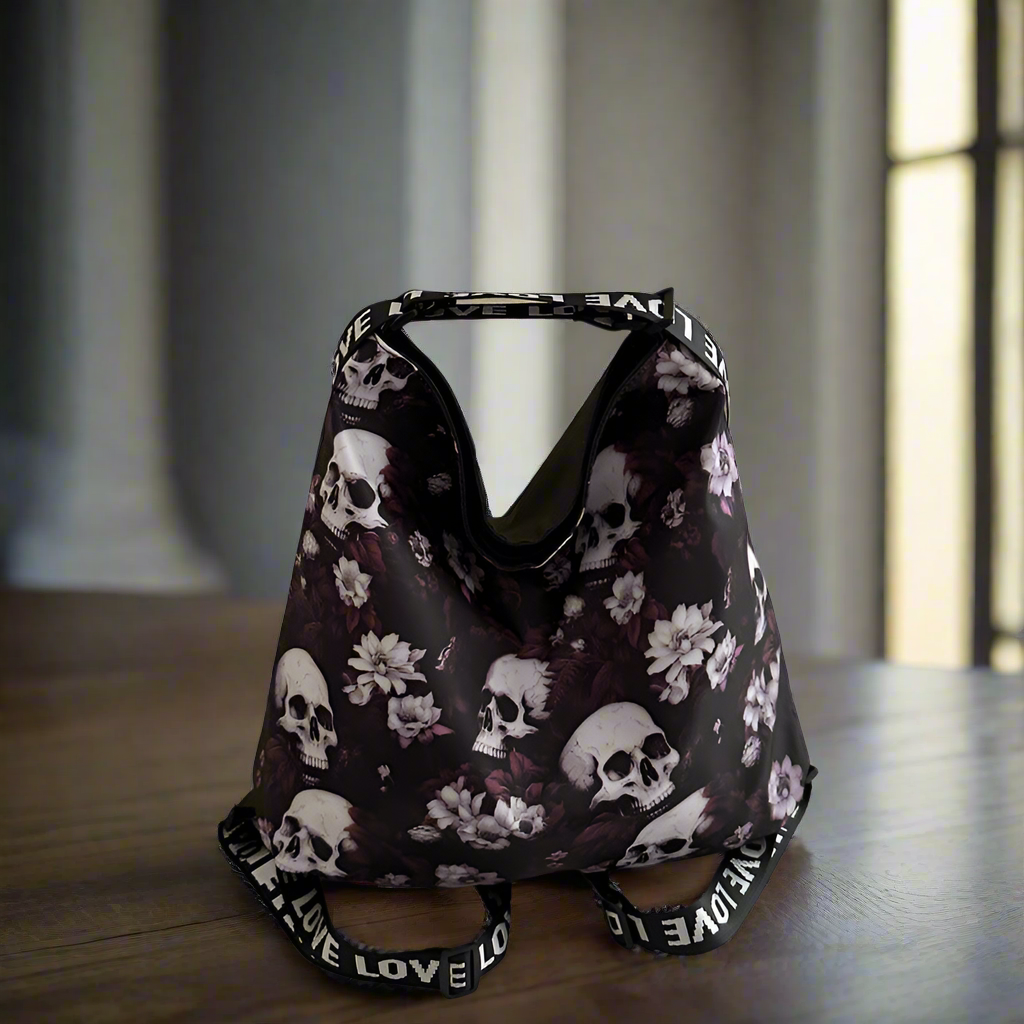 Floral and skull patterned bag with 'LOVE' strap on a wooden surface