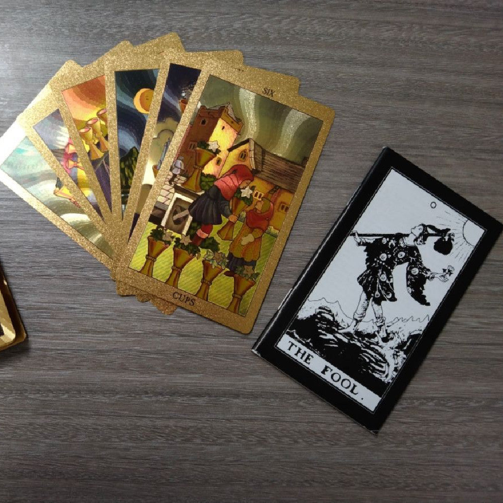 Set of tarot cards on a wooden surface with 'The Fool' card displayed.