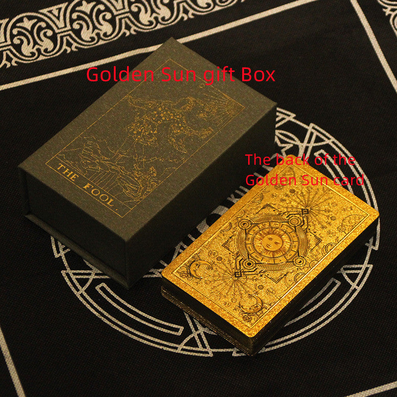 Gold tarot card and box on a black background with intricate designs
