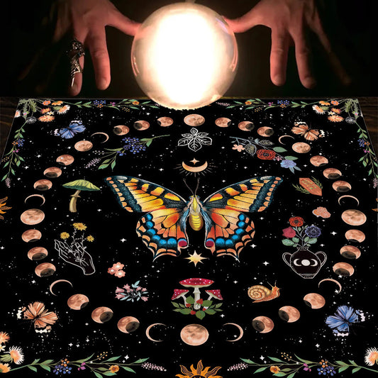 Crystal ball held above a tablecloth with butterfly and celestial designs