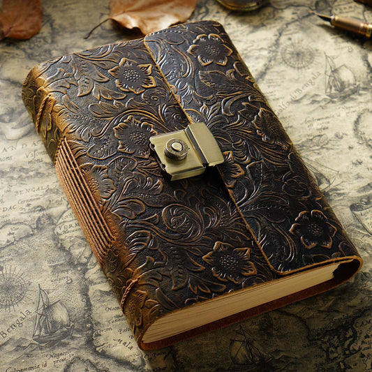 Decorative leather-bound notebook with floral embossing on a vintage map background